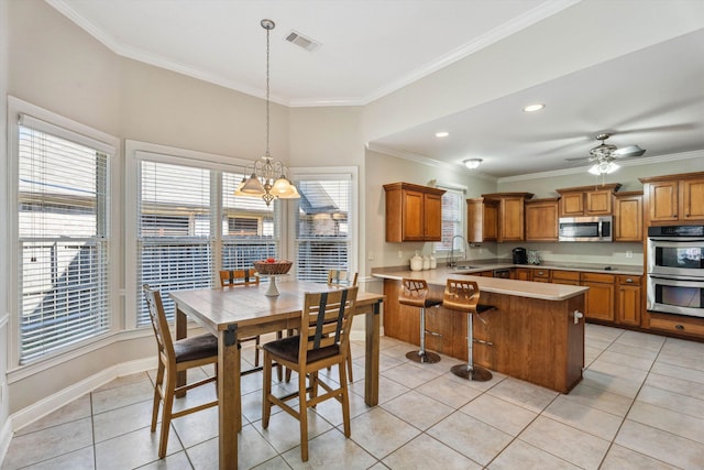 dining area with ceiling fan with notable chandelier, crown molding, sink, and light tile patterned floors