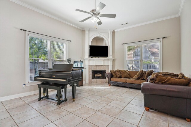 living room featuring ceiling fan, light tile patterned flooring, crown molding, and a healthy amount of sunlight