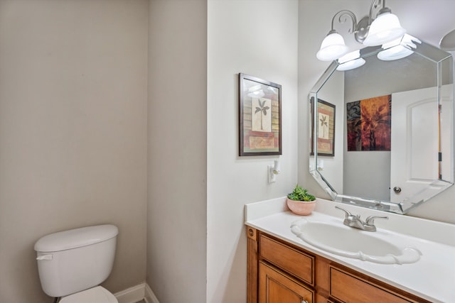 bathroom featuring an inviting chandelier, vanity, and toilet