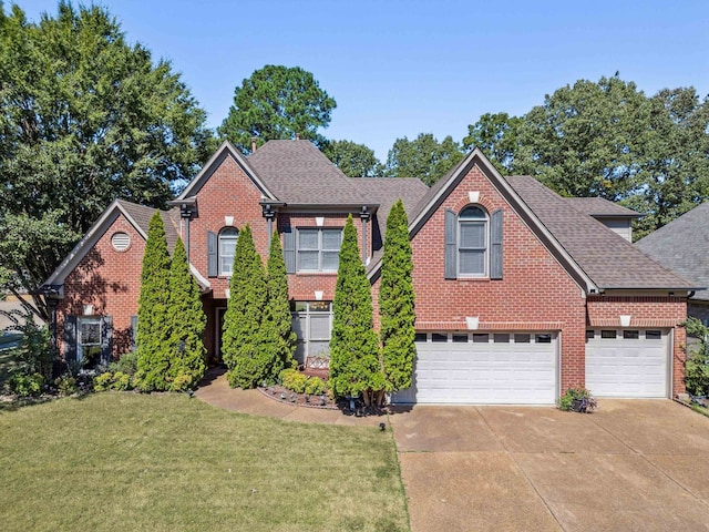 front of property with a garage and a front lawn