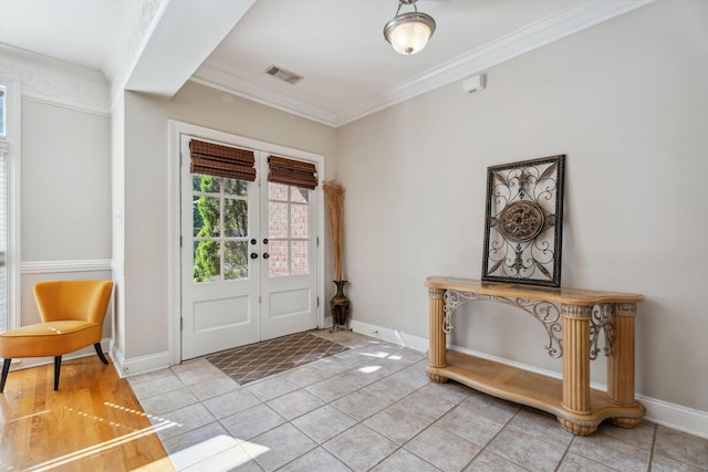 foyer with french doors, ornamental molding, and light tile patterned floors