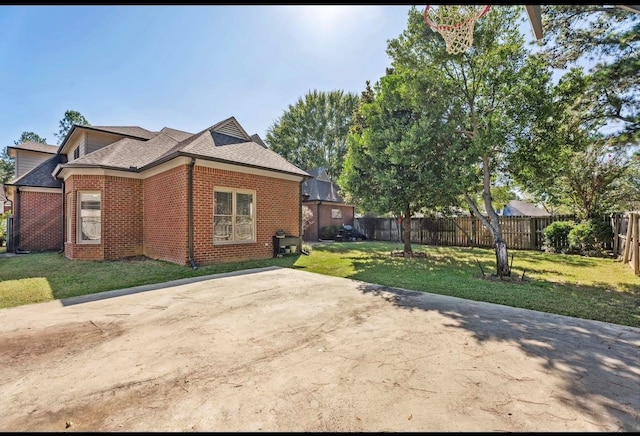 view of side of property with a patio and a lawn