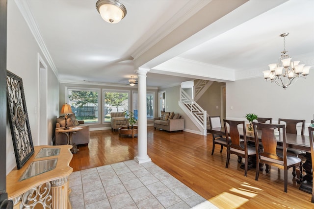 interior space with ornate columns, ceiling fan with notable chandelier, ornamental molding, and light hardwood / wood-style flooring