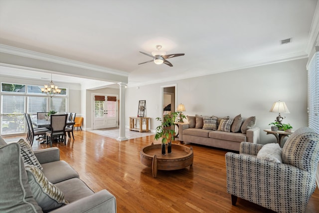 living room featuring ornate columns, crown molding, hardwood / wood-style flooring, and a healthy amount of sunlight