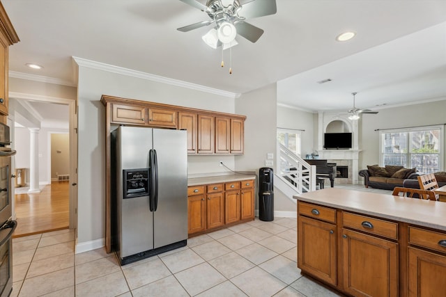 kitchen with ornamental molding, light tile patterned flooring, ornate columns, and stainless steel fridge with ice dispenser