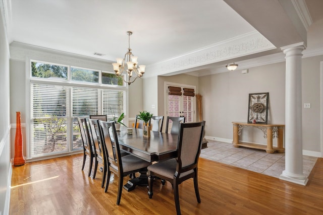 dining room featuring ornamental molding, a chandelier, ornate columns, and light hardwood / wood-style flooring