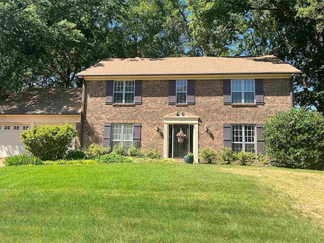 colonial home with a front yard and a garage