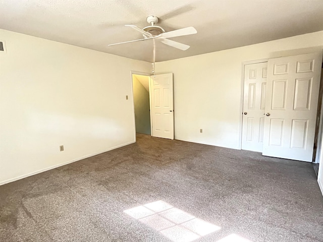 unfurnished bedroom featuring a closet, ceiling fan, and dark colored carpet