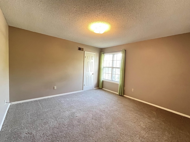 carpeted spare room featuring a textured ceiling