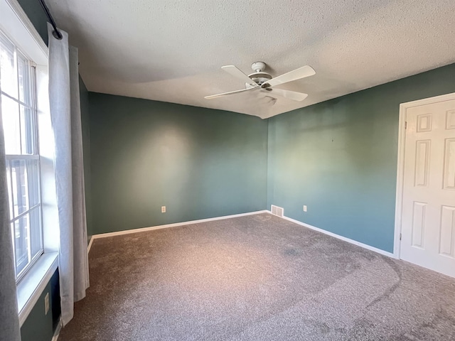 spare room with carpet, a textured ceiling, and ceiling fan