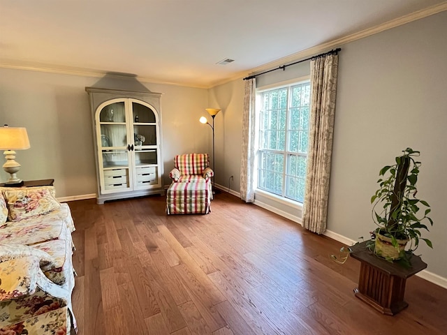 sitting room with crown molding and hardwood / wood-style flooring