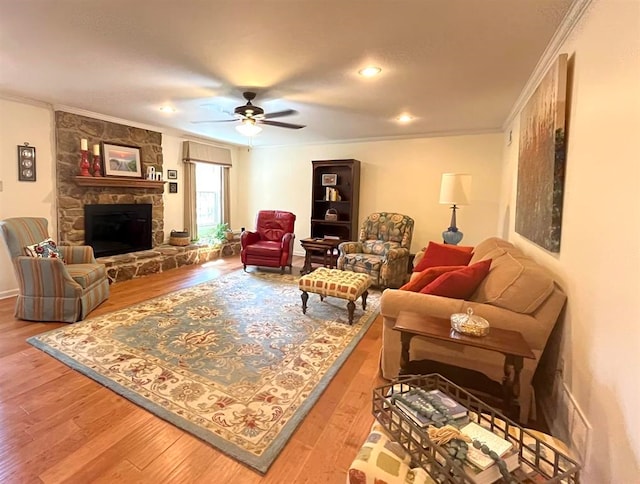 living room with crown molding, hardwood / wood-style flooring, a fireplace, and ceiling fan