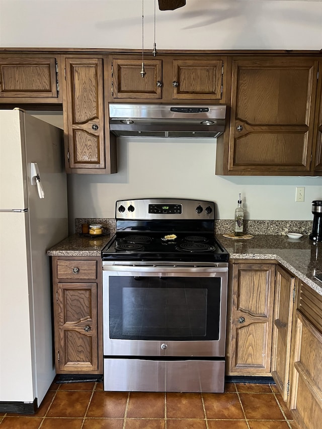 kitchen with stainless steel range with electric stovetop, dark stone countertops, ventilation hood, dark tile patterned flooring, and white fridge