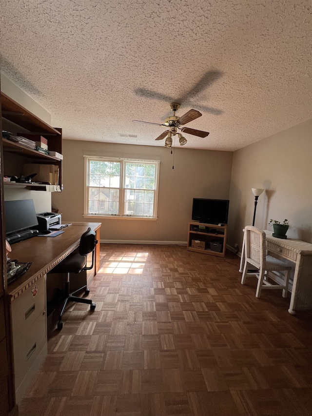 office with dark parquet flooring, ceiling fan, and a textured ceiling