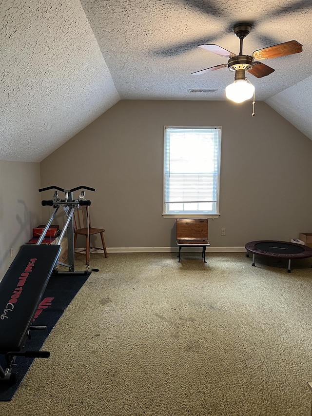 additional living space featuring ceiling fan, lofted ceiling, carpet floors, and a textured ceiling