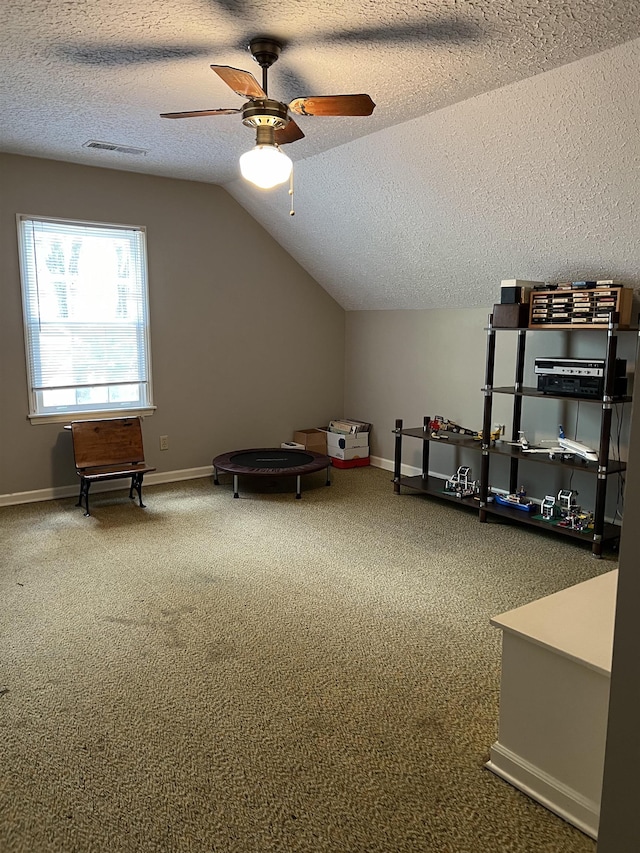 bonus room featuring ceiling fan, vaulted ceiling, a textured ceiling, and carpet