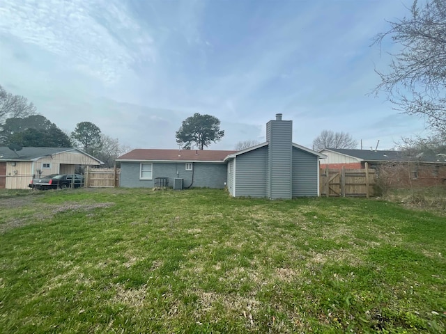 rear view of property with a lawn and central AC