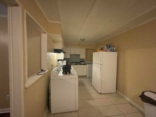 kitchen with white cabinets, light tile patterned floors, white fridge, and tasteful backsplash