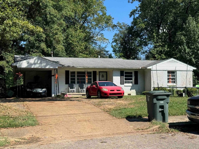 ranch-style house featuring covered porch and a carport