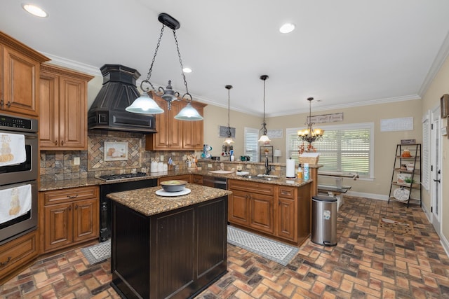 kitchen featuring pendant lighting, sink, custom range hood, a kitchen island, and stainless steel appliances