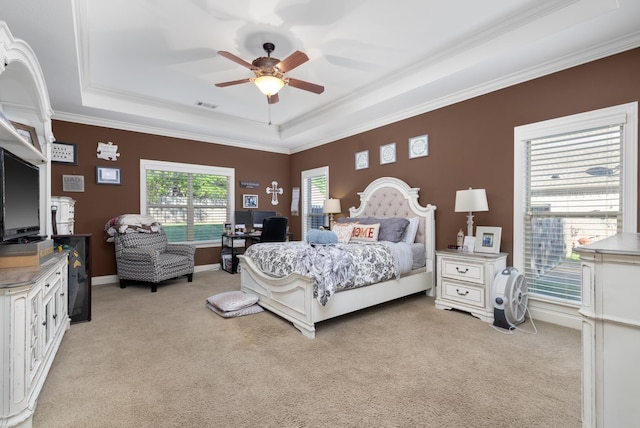 bedroom with ceiling fan, a raised ceiling, light carpet, and ornamental molding