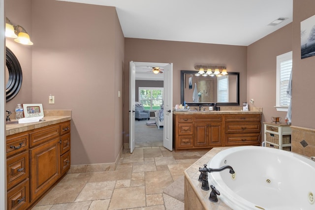 bathroom featuring ceiling fan, tiled tub, and vanity