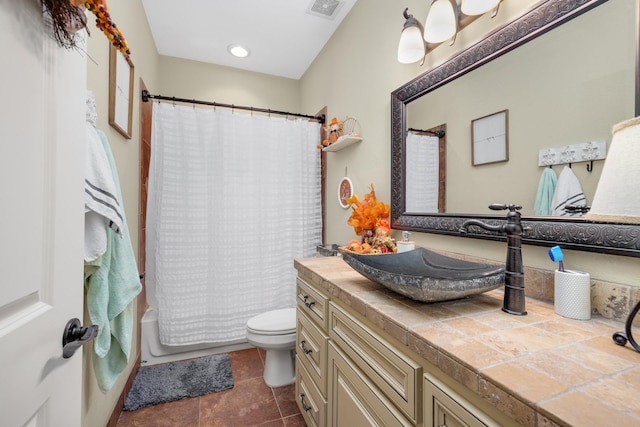 full bathroom with shower / bath combo with shower curtain, tile patterned floors, vanity, and toilet