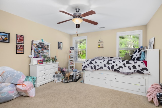 carpeted bedroom with multiple windows and ceiling fan