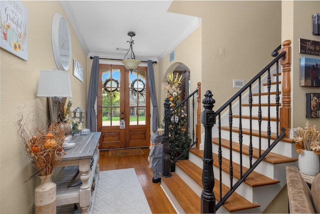 foyer featuring french doors, hardwood / wood-style flooring, and crown molding