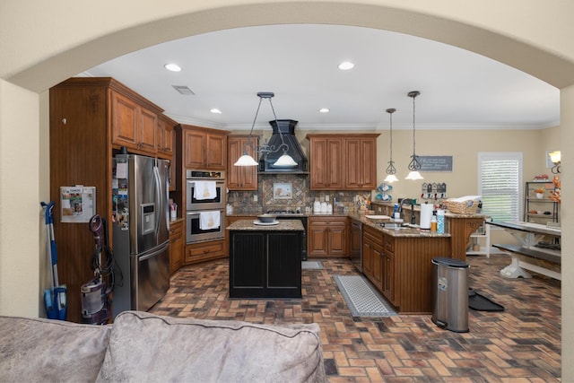 kitchen featuring pendant lighting, backsplash, stainless steel appliances, custom range hood, and a center island