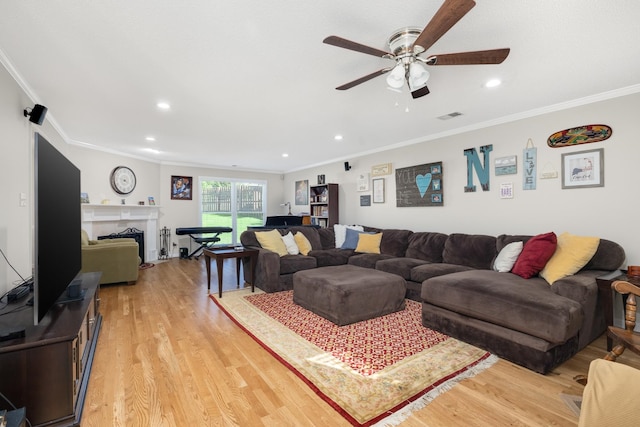 living room featuring ornamental molding, ceiling fan, and light hardwood / wood-style floors