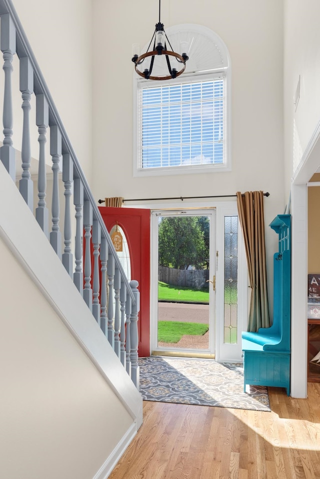 foyer featuring a chandelier, a high ceiling, and light wood-type flooring