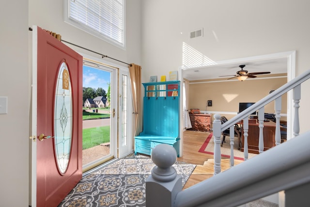 foyer entrance featuring ceiling fan, hardwood / wood-style floors, and a high ceiling