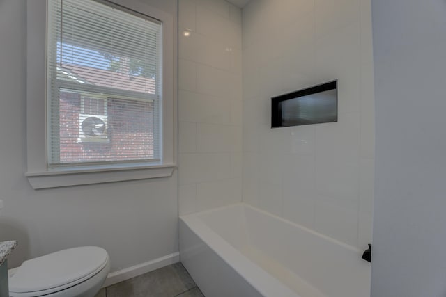 bathroom with tile patterned floors, toilet, and tiled shower / bath combo