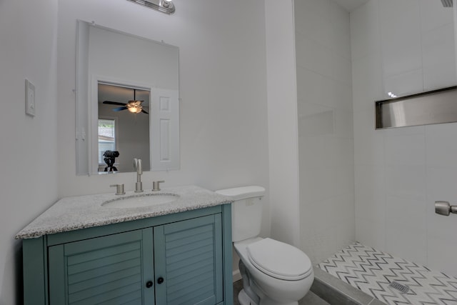 bathroom featuring vanity, tiled shower, and toilet