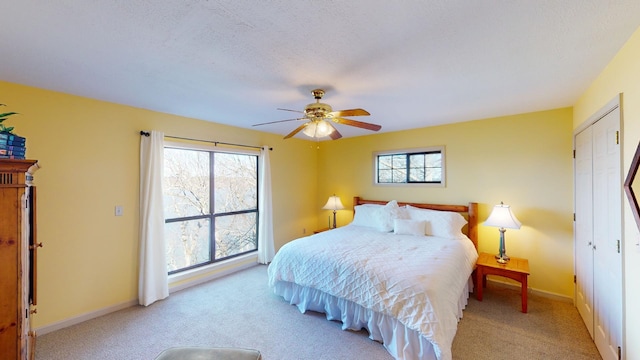 bedroom with light carpet, multiple windows, and ceiling fan