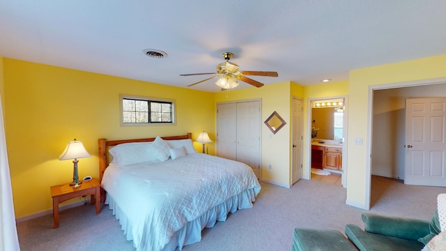 bedroom with ceiling fan, light carpet, connected bathroom, and a closet