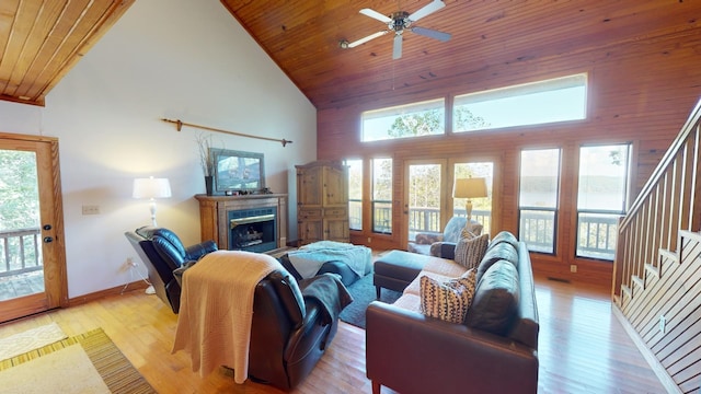 living room with plenty of natural light, light wood-type flooring, wood ceiling, and high vaulted ceiling