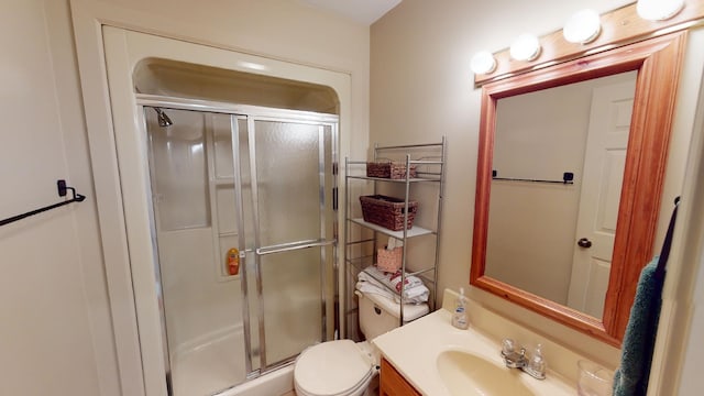 bathroom with toilet, an enclosed shower, and vanity