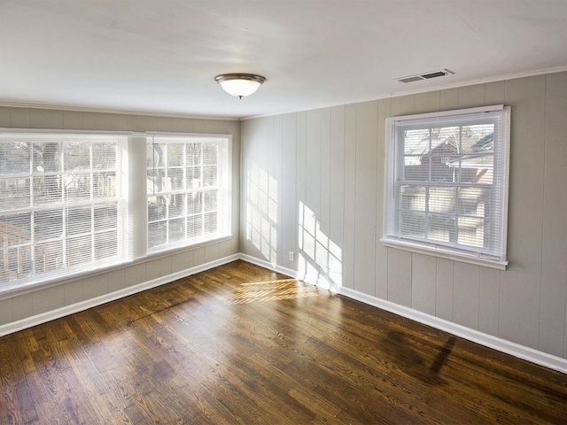 empty room with wood walls and dark hardwood / wood-style floors