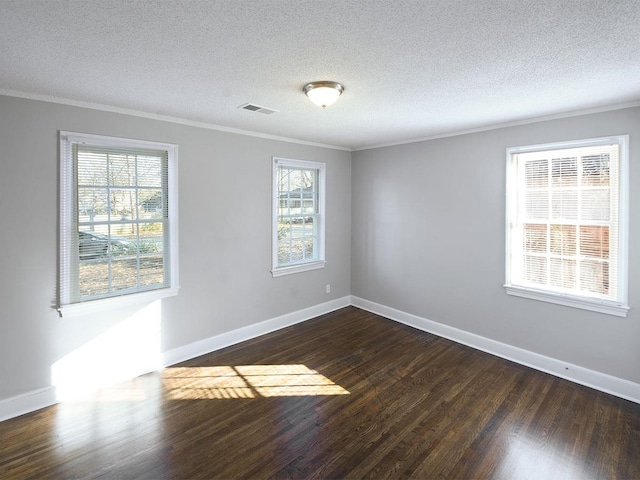 empty room with ornamental molding, a textured ceiling, and dark wood-type flooring