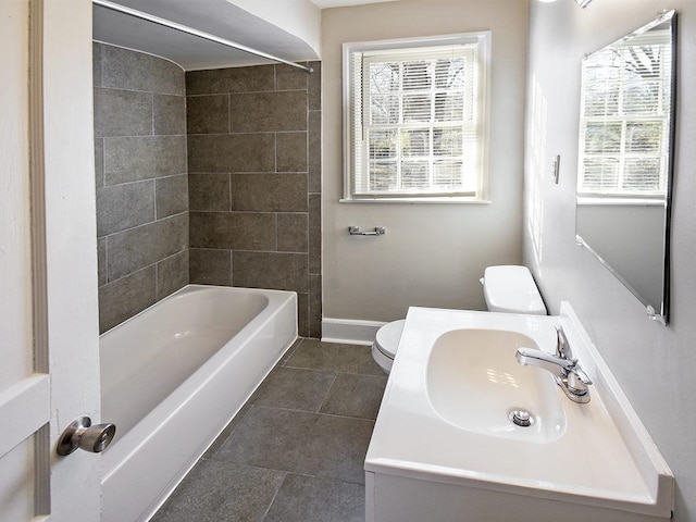 full bathroom with tile patterned flooring, tiled shower / bath combo, a healthy amount of sunlight, and toilet