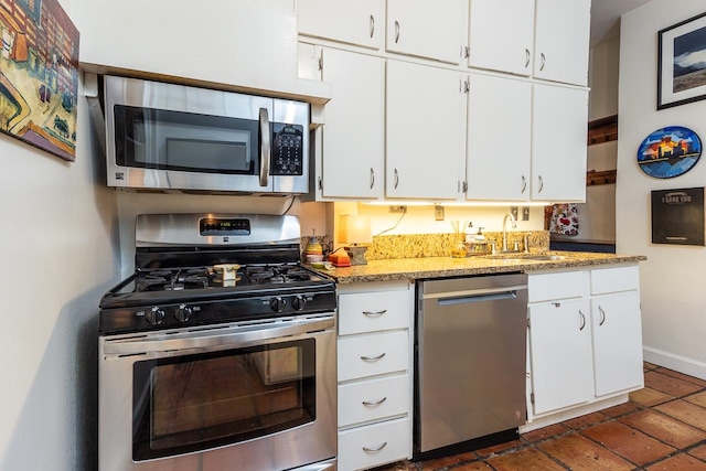 kitchen featuring stone counters, white cabinetry, sink, and stainless steel appliances