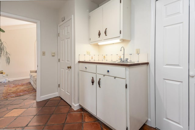 bar featuring sink and white cabinets