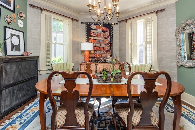 dining space with ornamental molding, a chandelier, and hardwood / wood-style flooring