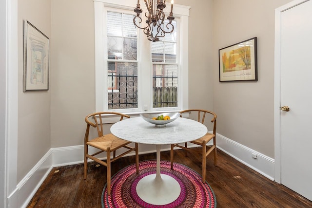 dining room with baseboards, a notable chandelier, and dark wood finished floors