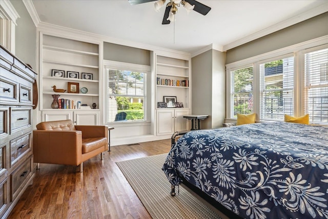 bedroom with ceiling fan, ornamental molding, dark hardwood / wood-style flooring, and multiple windows