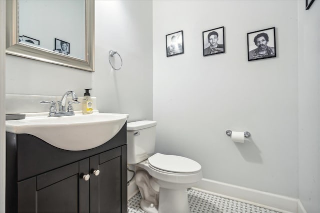 bathroom with toilet, tile patterned floors, vanity, and baseboards
