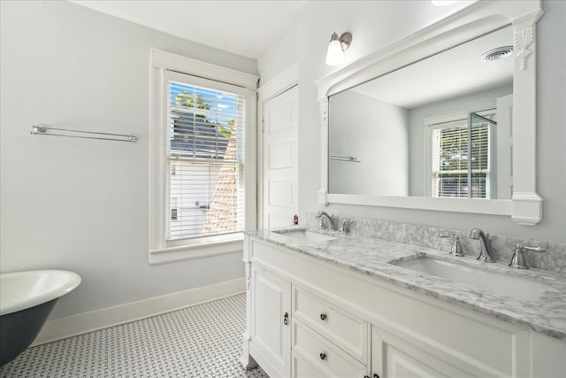 bathroom featuring a tub to relax in, plenty of natural light, vanity, and tile patterned floors