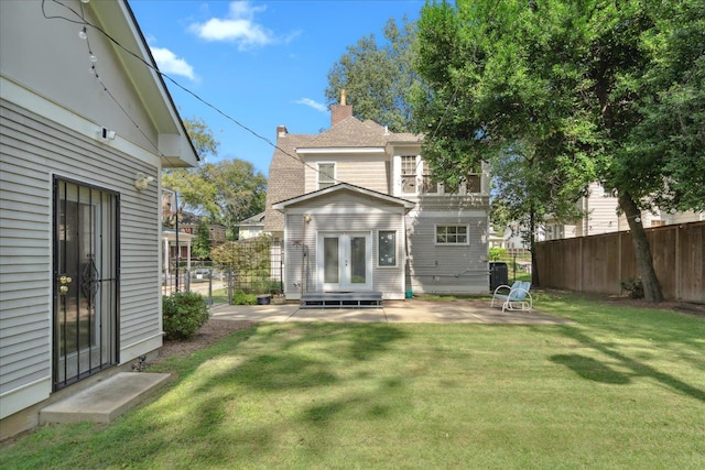 back of house featuring a lawn and a patio area